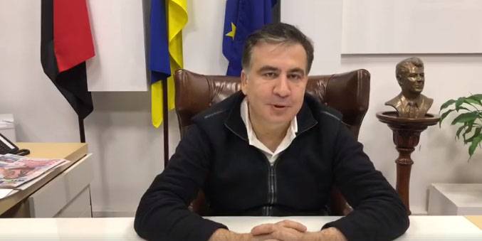 De Saakaschwili gezeechent, d ' Adress zu Poroshenko virun dem hannergrond vun der Fahnen der Ukrain, der EU an der 