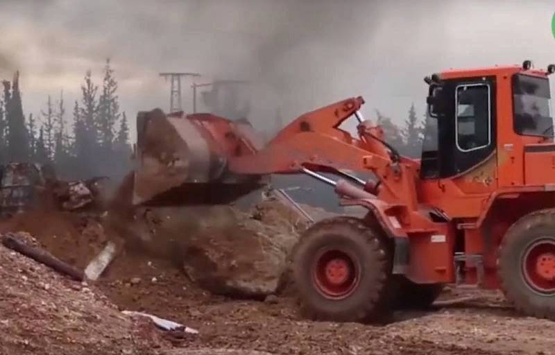 En syrie, le 20 mars: turcs de bulldozers et de militants nettoient la piste M4 à Idlib